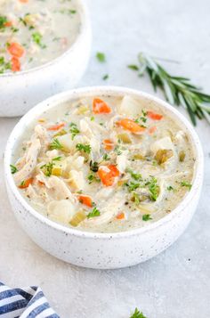 two white bowls filled with chicken and vegetable soup