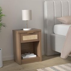 a bedroom with a bed, nightstand and plant on the side table next to it