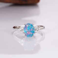 A Touch of Brilliance: The Tya Ring. This handcrafted sterling silver ring features a mesmerizing natural blue fire opal, its color captivating with every twist of your hand. A timeless piece that adds instant elegance to any look (sizes 3.5-14.25). ✦ DETAILS ✦ ✧ Handcrafted ✧ Natural opal and natural crystals ✧ Sizes 3.5-14.25 ✧ This ring set will arrive ready to gift in a Kherish velvet box. ✧ Due to the nature of the crystals, each piece may vary in color, size, shape, and contain natural inc