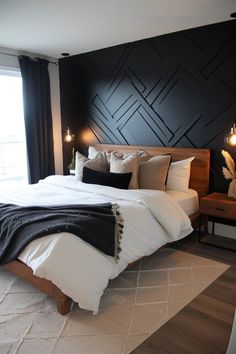 a bedroom with black accent wall and white bedding