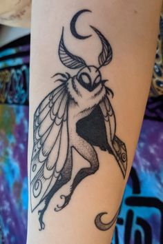 a black and white photo of a bird on someone's arm with the moon behind it