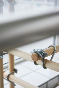 a close up of a wooden rail with metal straps on it and someone's feet in the background