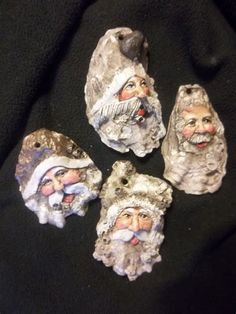 four santa claus figurines sitting on top of a black cloth