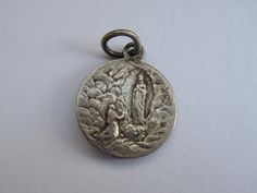 Religious antique French silver ( MARKED ) catholic medal pendant charm medallion of Holy Virgin Mary of Lourdes. Measures are 0,659 x 0,7 inches ( 1,52 x 1,79 cm ) I bought this beautiful antique medal on a brocante ( fleamarket ) in France. I deliver all over the world. If you want more photos or information, you can contact me. If you don't have paypal, you can pay by bank transfer. Registered shipping is possible. Please take a look at my other items for sale.Registered shipping is possible Silver Miraculous Medal Pendant, Silver Pendant With Miraculous Medal, Vintage Miraculous Medal Medallion Jewelry, Vintage Miraculous Medal Medallion, Miraculous Medal For Commemoration, Vintage Miraculous Medal On Round Pendant, Vintage Miraculous Medal Round Pendant, Miraculous Medal Medallion For Commemoration, Our Lady Of Sorrows