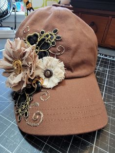 a hat with flowers on it sitting on top of a table