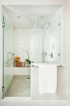 a white bathroom with a glass shower door