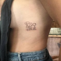 an elephant and giraffe tattoo on the back of a woman