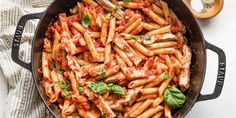 a pan filled with pasta and sauce on top of a table