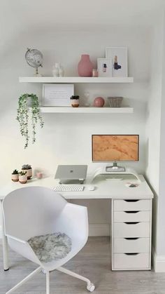 a white desk with a computer on top of it and shelves above the desk behind it