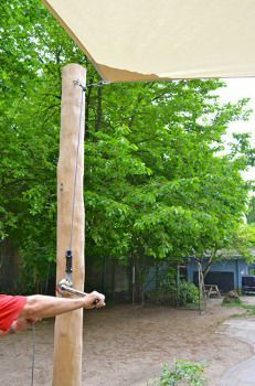 a man in red shirt holding a baseball bat on top of a wooden pole next to trees