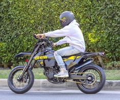 a man riding on the back of a motorcycle down a street