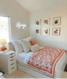 a bedroom with white walls and pictures on the wall above the bed that says happy