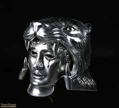 a silver mask is shown against a black background