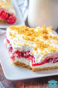 a piece of cake on a white plate with glasses next to it and a glass of milk in the background