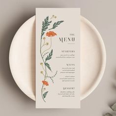 the menu card is sitting on top of a plate with flowers and leaves around it