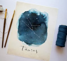 a card with the zodiac sign taurus on it next to some yarn and scissors