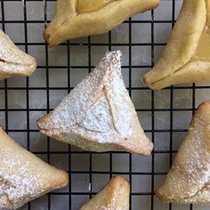 several pastries on a cooling rack with powdered sugar in the shape of triangles