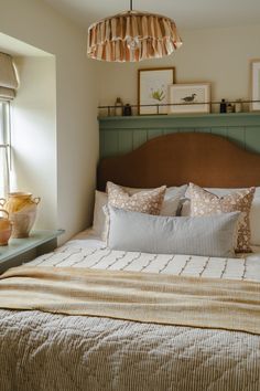 a bedroom with a bed, dresser and window in the corner that has a lamp hanging above it