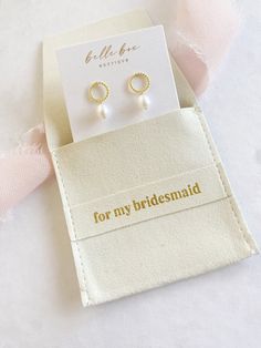 the bridesmaid earrings are in their pouch