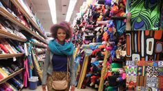 a woman is standing in the aisle of a store with many items on display behind her