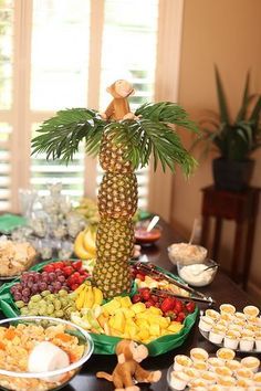 a table topped with lots of different types of foods and desserts next to a window