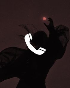 the silhouette of a woman holding a cell phone up to her ear and wearing a veil