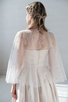 the back of a woman's wedding dress with long sleeves and beaded details