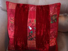 a red decorative pillow sitting on top of a couch