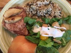 a white plate topped with meat, rice and salad