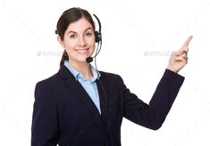 a woman wearing a headset pointing to the side with her finger up - stock photo - images