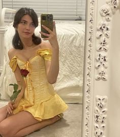 a woman in a yellow dress taking a selfie