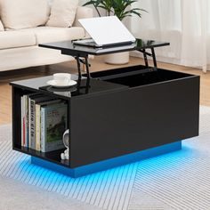 a coffee table with a laptop on top and blue light underneath it, in front of a couch