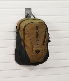 a brown and black backpack hanging on a white wall with the word columbia printed on it