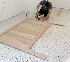 a man is working on the floor in his room with wood planks and glue