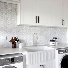 a kitchen with white cabinets and a washer and dryer