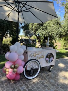 an ice cream cart is decorated with balloons