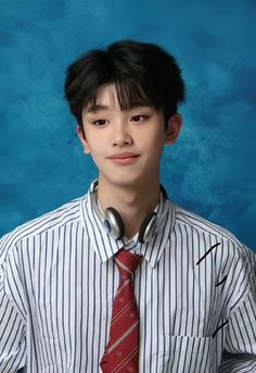 a young man wearing a striped shirt and red tie