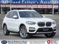 a white bmw suv is parked in front of a dealers showroom with the words good fellow's auto