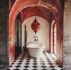 an old fashioned bathtub in the middle of a room with black and white checkered flooring