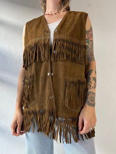 - Vintage suede leather fringe vest - Snaps up the front - A few water marks throughout - No tags - Medium Chest: 20" Length: 29" We are not responsible for lost, stolen, or damaged packages once they have been shipped. Any additional customs duties or taxes incurred on international orders are the responsibility of the buyer. Please note that our items are vintage and may have minor flaws or imperfections due to their age, which adds to their unique character. Fall Festival Vest With Fringe, Bohemian Brown Vest With Fringe, Brown Bohemian Vest With Fringe, Bohemian Brown Fringe Vest, Brown Bohemian Fringe Vest, Brown Fringe Vest For Festival, Festival Fringe Brown Vest, Brown Fringe Vest For Fall, Brown Sleeveless Fringe Vest