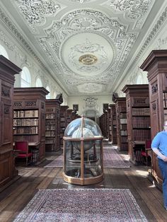 a man standing in the middle of a room with lots of bookshelves and shelves