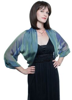 "This gorgeous airy bolero jacket has loose-fitting silhouette made of finest 100% silk iridescent chiffon of aqua-blue color. Sophisticated color of aqua shows a beautiful play of shades tone from grey to light green with purple-teal warm hint, which are changing depending from intensity and angle of light. It has luxurious details such as wide soft folds attached to the bolero's edges. The long sheer sleeves are adorned with lovely handmade silk rosettes centered with Austrian Swarovski crysta Formal Bolero, Wear Shawl, Chiffon Bolero, Silk Clutch, First Ladies, Wedding Shrug, Aqua Blue Color, Shrugs And Boleros, Bolero Jacket