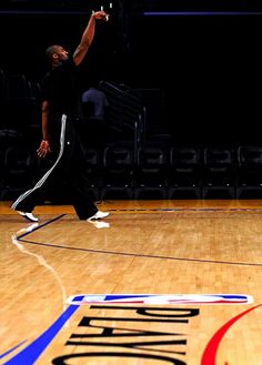 a man standing on top of a basketball court holding a racquet in his hand