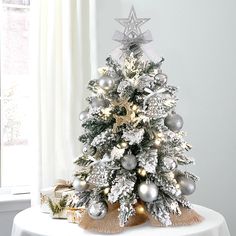 a silver and white christmas tree on a table