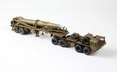 a toy army truck with a missile on it's flatbed trailer and wheels