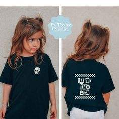 A perfect shirt for those wild child, punk rock kids in your life ! Front shows a skull + back shows trendy checkered graphics with an In My Emo Era writing for all the nearly feral toddlers with Elder Emo parents.  SHIRT COLOR IS BLACK. Thank you for supporting our small, toddler mama + family run business! We love being able to provide you with trendy designs to make your kiddo the coolest on the block! The Bella Canvas short sleeve tee for toddlers is a 100% Airlume combed and ring-spun cotto Cotton Rocker Top With Graphic Design, Unisex Graphic Print Rocker Tops, Band Merch Graphic Print Top For Birthday, Black Band Merch T-shirt For Birthday, Elder Emo, Toddler Gift, Mom Baby, Birthday Tee, Trendy Designs