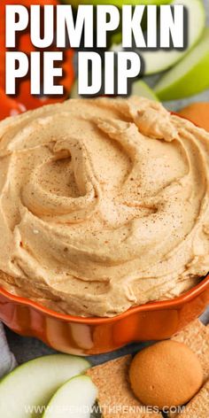 pumpkin pie dip in an orange bowl surrounded by crackers and apples on the side