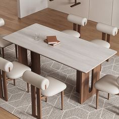 a dining room table with six chairs and a book on the end, in front of an area rug