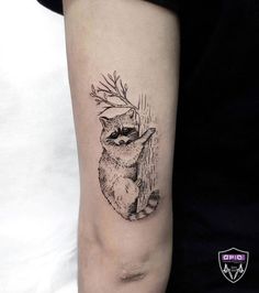 a small raccoon tattoo on the arm