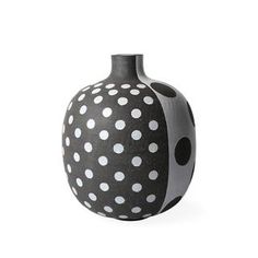 a black and white vase with polka dots on the outside, sitting in front of a white background